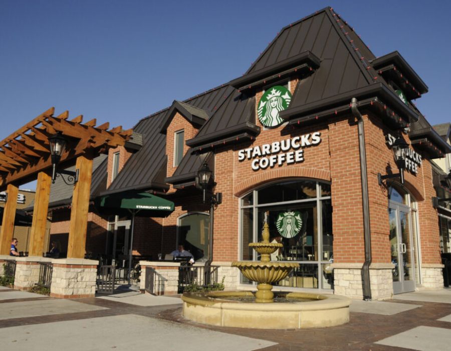Sonder A Starbucks coffee shop exterior featuring the iconic green logo and outdoor seating area.
