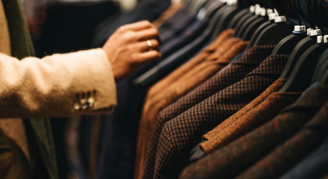 Woman shopping and picking out different dress shirts